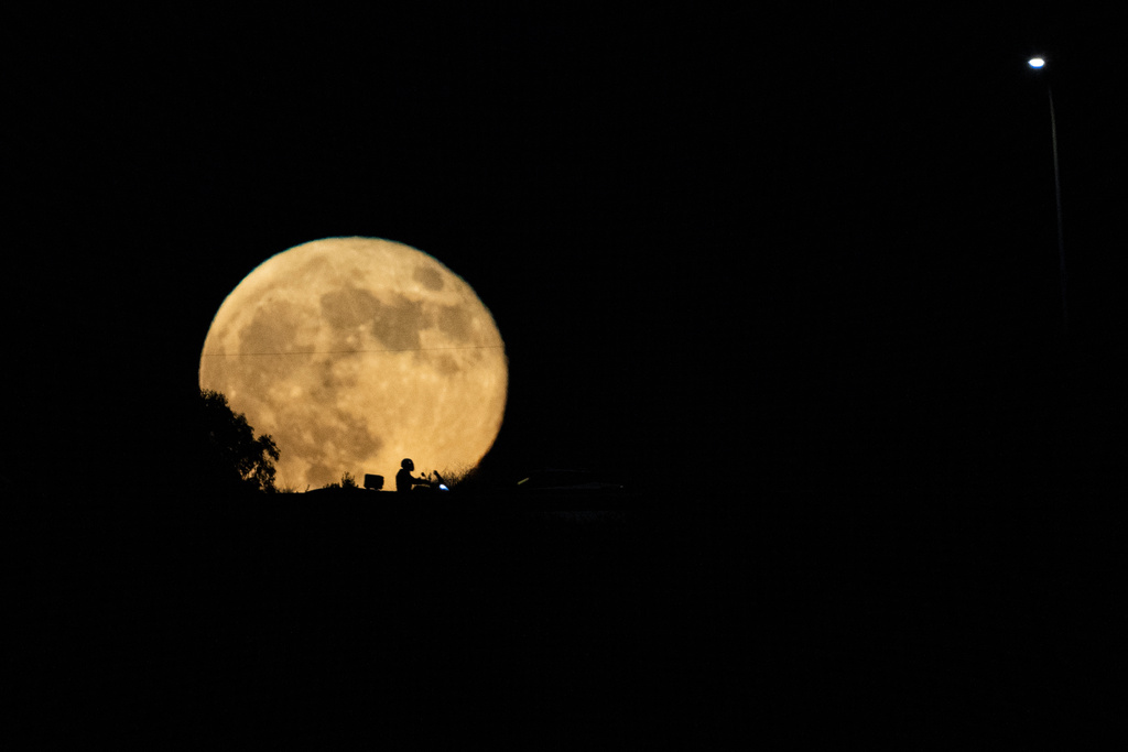 FILE - The moon rises in the sky over a freeway as drivers pass between Haifa and Tel Aviv, Israel, Wednesday, Sept. 18, 2024. (AP Photo/Ariel Schalit, File)