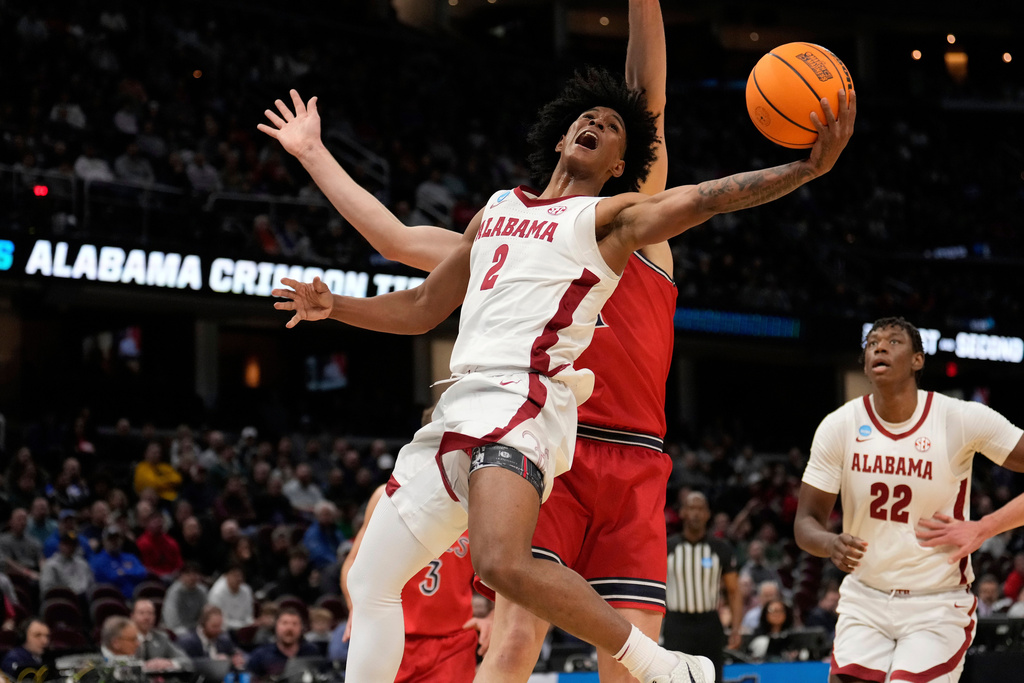 FILE - Alabama guard Aden Holloway (2) shoots in front of Saint Mary's center Harry Wessels, rear, in the first half of the second round of the NCAA college basketball tournament, March 23, 2025, in Cleveland. (AP Photo/Sue Ogrocki, File)