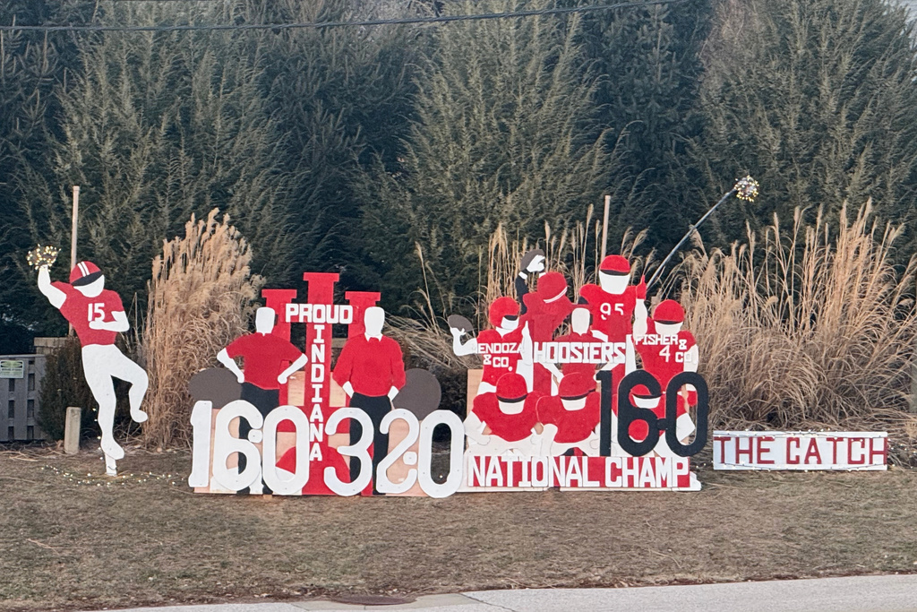 Wooden cutouts showing support for Indiana University line a street near Memorial Stadium on Tuesday, Jan. 20, 2026, in Bloomington, Ind. (AP Photo/Mike Marot)