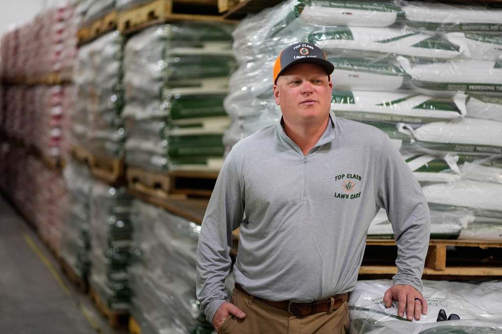 Top Class Lawn Care owner Jake Wilson stands by fertilizer he stockpiled at his supplier's warehouse in anticipation of Iran war related price hikes Thursday, March 26, 2026, in Riverside, Mo. (AP Photo/Charlie Riedel)