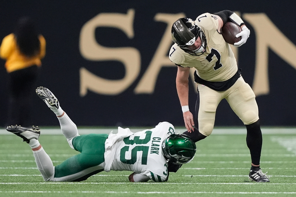 New Orleans Saints tight end Taysom Hill (7) holds on to the ball after a pass completion as New York Jets safety Dean Clark (35) defends during the first half of an NFL football game Sunday, Dec. 21, 2025, in New Orleans. (AP Photo/Gerald Herbert)