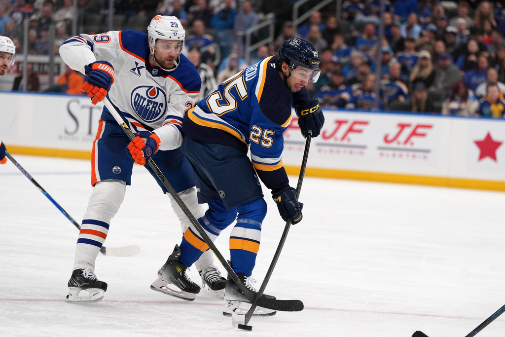 St. Louis Blues' Jordan Kyrou (25) handles the puck as Edmonton Oilers' Leon Draisaitl (29) defends during the second period of an NHL hockey game Monday, Nov. 3, 2025, in St. Louis. (AP Photo/Jeff Roberson)