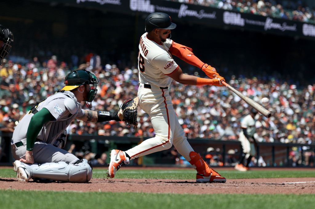 San Francisco Giants' Victor Bericoto (78) hits a two-run home run in front of Athletics catcher Jonah Heim (15) during the sixth inning of a baseball game in San Francisco, Thursday, June 25, 2026. (AP Photo/Jed Jacobsohn)
