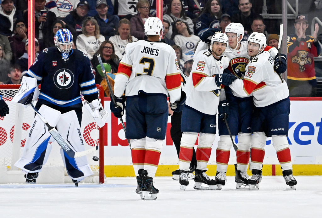 Florida Panthers' Sam Reinhart (13) celebrates his goal on Winnipeg Jets goaltender Clay Stevenson (33) with Brady Tkachuk (8), second from right, Seth Jones (3) and Matthew Tkachuk (19), right, during the second period of an NHL hockey game in Winnipeg, Manitoba, Tuesday, Oct. 27, 2026. (Fred Greenslade/The Canadian Press via AP)