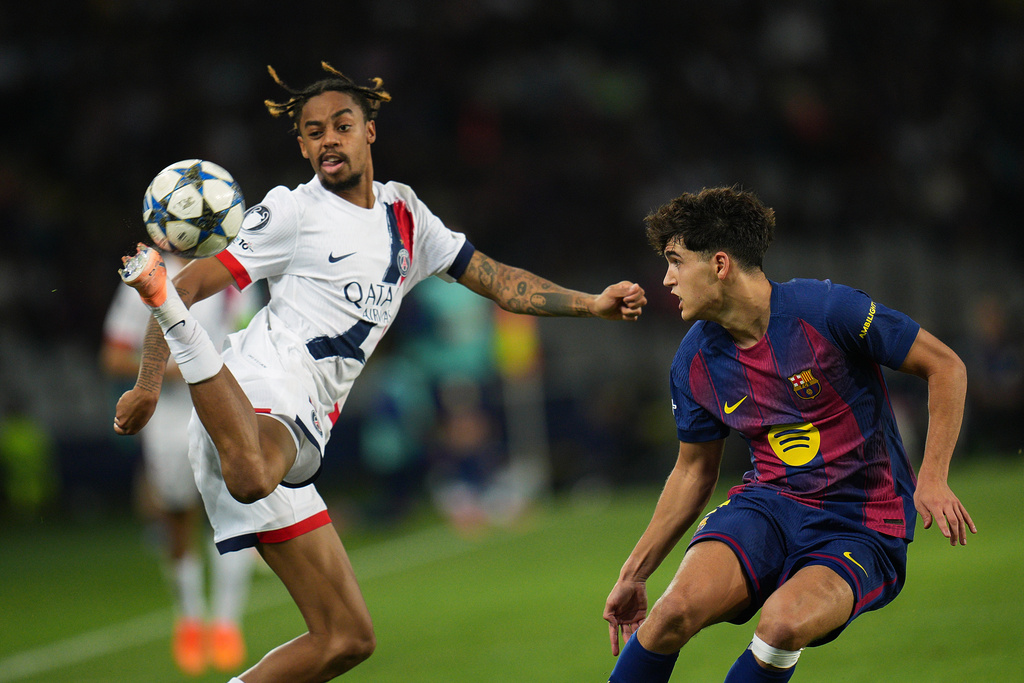 PSG's Bradley Barcola, left, challenges for the ball with Barcelona's Pau Cubarsi during the Champions League opening phase soccer match between Barcelona and Paris Saint-Germain at the Lluis Companys Olympic Stadium in Barcelona, Spain, Wednesday, Oct.1, 2025. (AP Photo/Emilio Morenatti)
