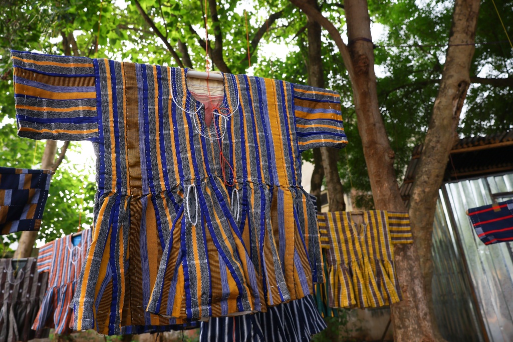Traditional fugu garments hang under a tree on display for sale along a street in Accra, Ghana, Wednesday, Feb. 18, 2026. (AP Photo/Tsraha Yaw)