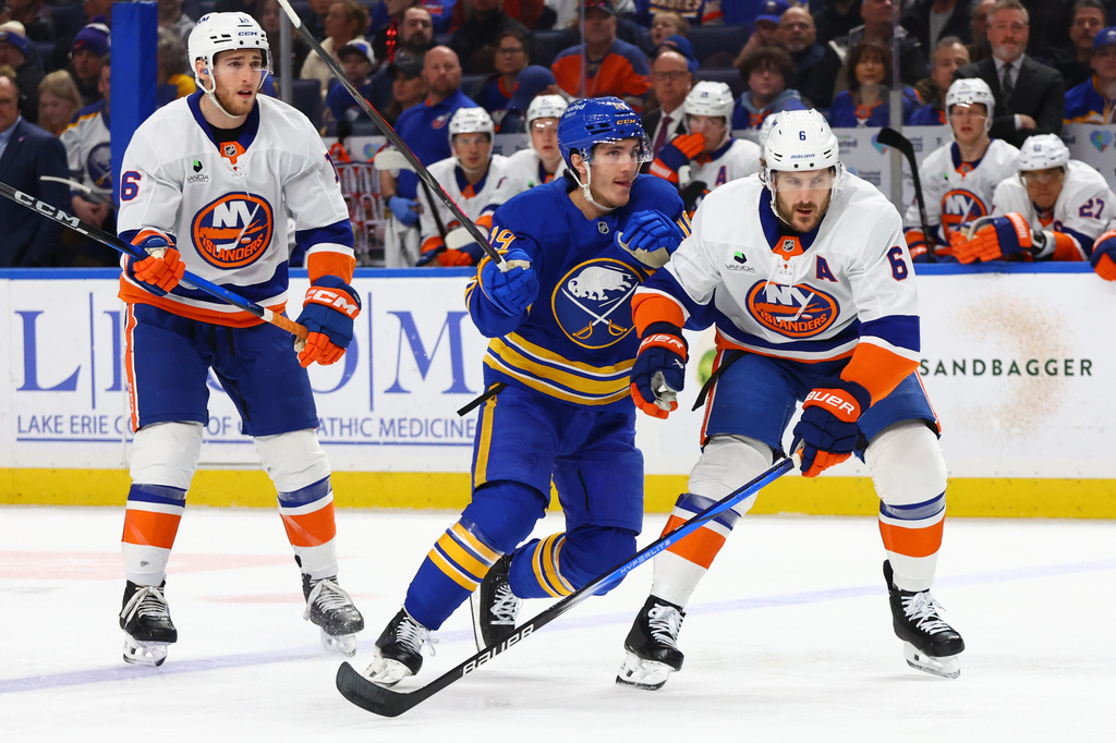 Buffalo Sabres center Peyton Krebs (19) skates between New York Islanders center Marc Gatcomb (16) and defenseman Ryan Pulock (6) during the first period of an NHL hockey game Tuesday, March 31, 2026, in Buffalo, N.Y. (AP Photo/Jeffrey T. Barnes)
