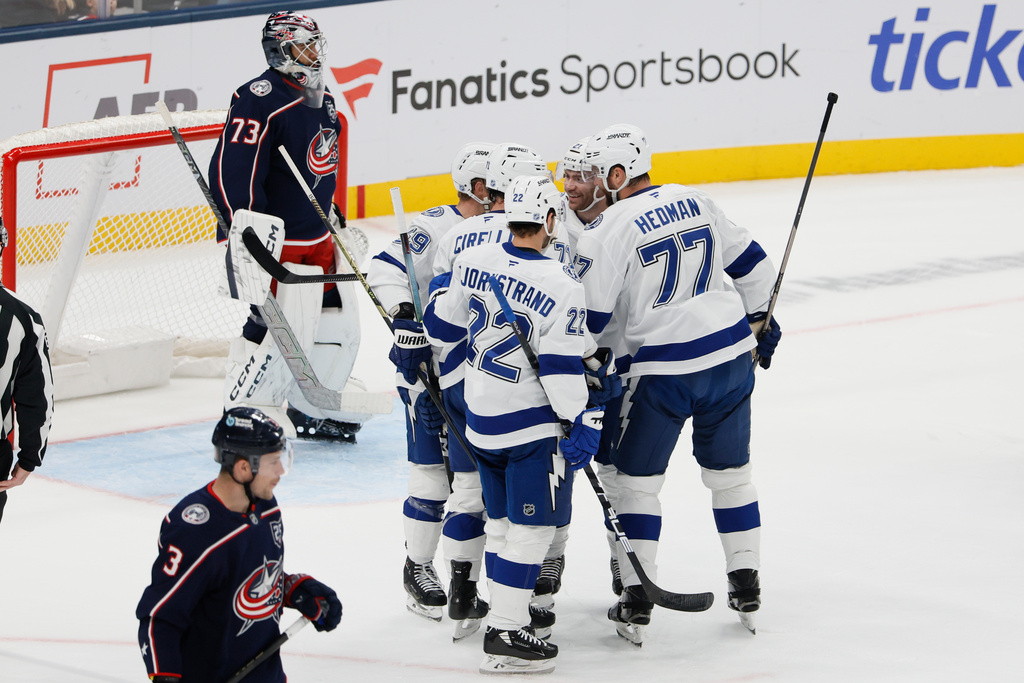 Tampa Bay Lightning players, right, celebrate after their goal against Columbus Blue Jackets' Jet Greaves (73) during the first period of an NHL hockey game, Saturday, Oct. 18, 2025, in Columbus, Ohio. (AP Photo/Jay LaPrete)
