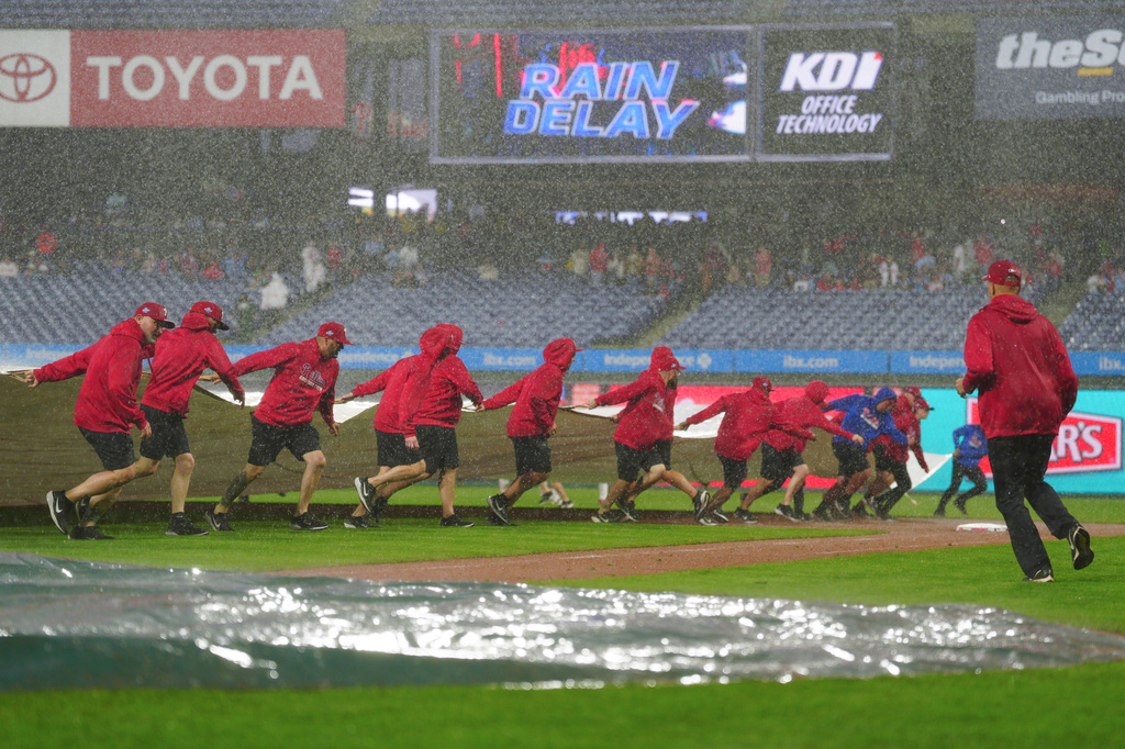 Grounds crew members pull a tarp onto the field during the sixth inning of the second baseball game of a doubleheader between the Philadelphia Phillies and the San Francisco Giants, Thursday, April 30, 2026, in Philadelphia. (AP Photo/Derik Hamilton)