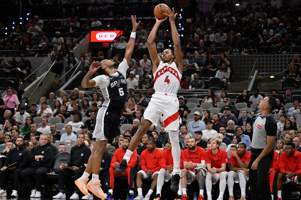 Toronto Raptors guard Scottie Barnes (4) shoots against San Antonio Spurs guard Stephon Castle during the second half of an NBA basketball game, Monday, Oct. 27, 2025, in San Antonio. (AP Photo/Darren Abate)