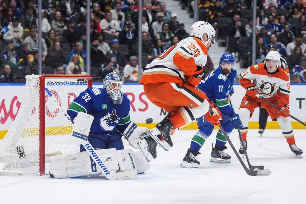 Vancouver Canucks goalie Kevin Lankinen (32) makes the save as Anaheim Ducks' Chris Kreider (20) jumps in front of him during the second period of an NHL hockey game, in Vancouver, on Tuesday, March 24, 2026. (Darryl Dyck/The Canadian Press via AP)