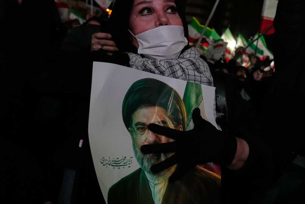 A woman holds a picture of the Iranian Supreme Leader Ayatollah Mojtaba Khamenei during a pro-government gathering in a square in western Tehran, Iran, Wednesday, March 25, 2026. (AP Photo/Vahid Salemi)