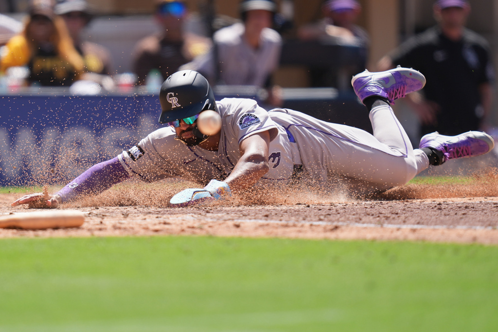 Colorado Rockies' Willi Castro slides in to score off an RBI single by Brett Sullivan during the seventh inning of a baseball game against the San Diego Padres Wednesday, July 29, 2026, in San Diego. (AP Photo/Gregory Bull)