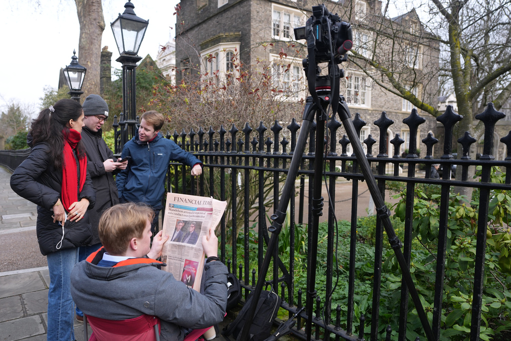 Journalists wait outside Peter Mandelson's house in London, Tuesday, Feb. 24, 2026 after Police in Britain say Peter Mandelson, the former U.K. ambassador to the United States, has been released on bail after he was arrested in an Epstein files misconduct probe. (AP Photo/Alastair Grant)
