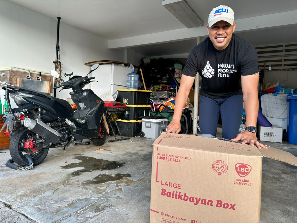 Sergio Alcubilla stands with a balikbayan box he sealed in Honolulu, on Monday, May 11, 2026. (AP Photo/Jennifer Sinco Kelleher)