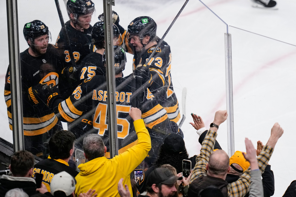 Boston Bruins left wing Lukas Reichel (75) is surrounded by teammates after his goal against Winnipeg Jets goaltender Connor Hellebuyck during the second period of an NHL hockey game, Thursday, March 19, 2026, in Boston. (AP Photo/Charles Krupa)