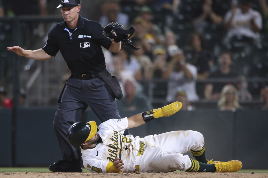 Athletics' Shea Langeliers scores on a wild pitch by Tampa Bay Rays pitcher Shane Baz (not shown) during the fifth inning of a baseball game Tuesday, Aug. 12, 2025, in West Sacramento, Calif. (AP Photo/Scott Marshall)
