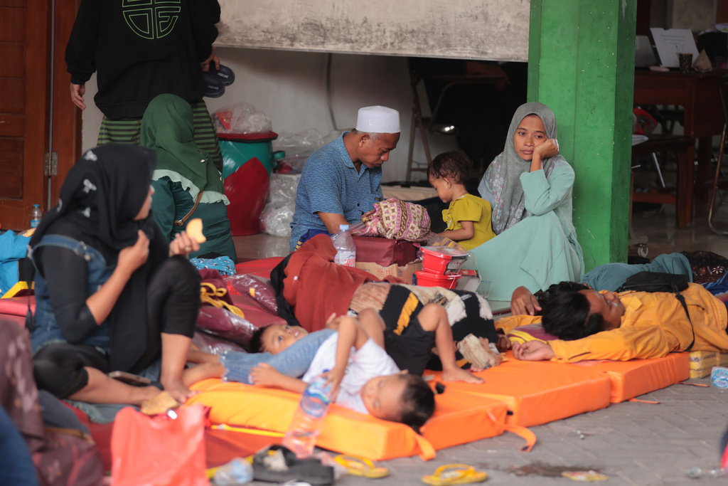 People wait as rescue work is underway after a building under construction collapsed at an Islamic boarding school in Sidoarjo, East Java, Indonesia, Tuesday, Sept. 30, 2025. (AP Photo/Trisnadi)