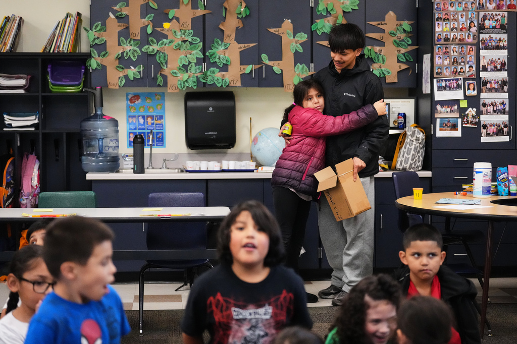 Chief Leschi Schools senior Gerald Dillon, 18, gets a hug from a second grade student as he serves as a teaching assistant through the school's career and technical education program, Wednesday, March 18, 2026, at Chief Leschi Schools in Puyallup, Wash. (AP Photo/Lindsey Wasson)