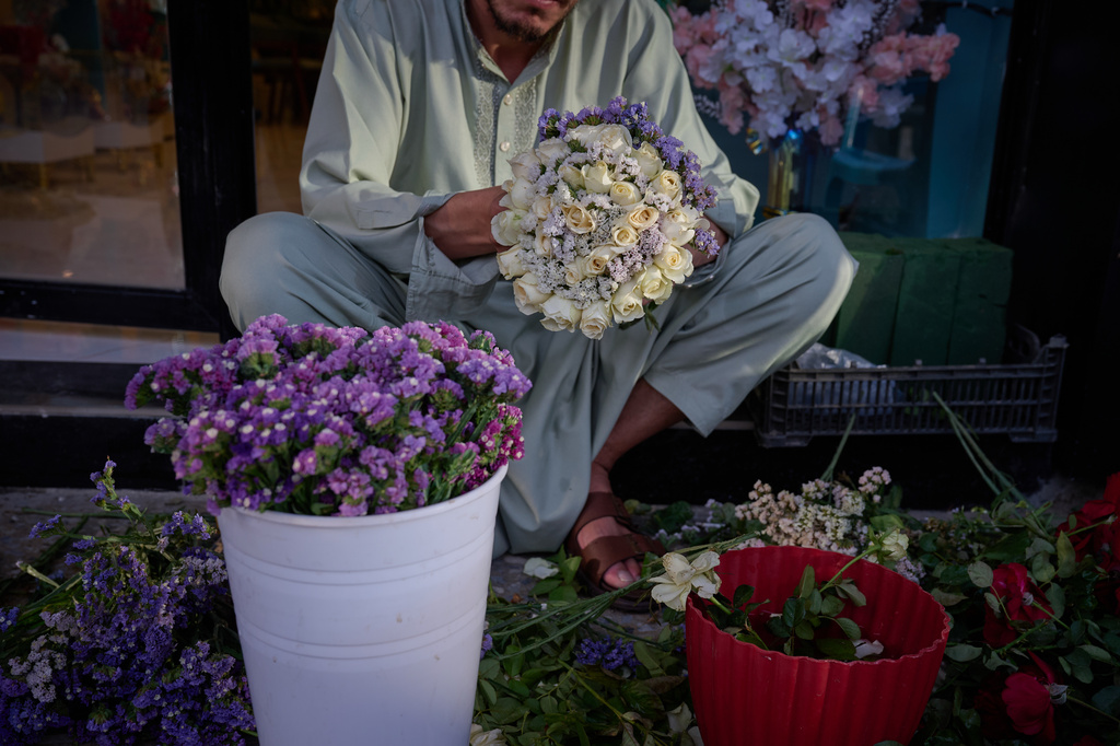 A flower seller arranges bouquets ahead of celebrations marking the fifth anniversary of the U.S. withdrawal and the start of Taliban rule in Kabul, Afghanistan, Friday, Aug. 14, 2026. (AP Photo/Nava Jamshidi)