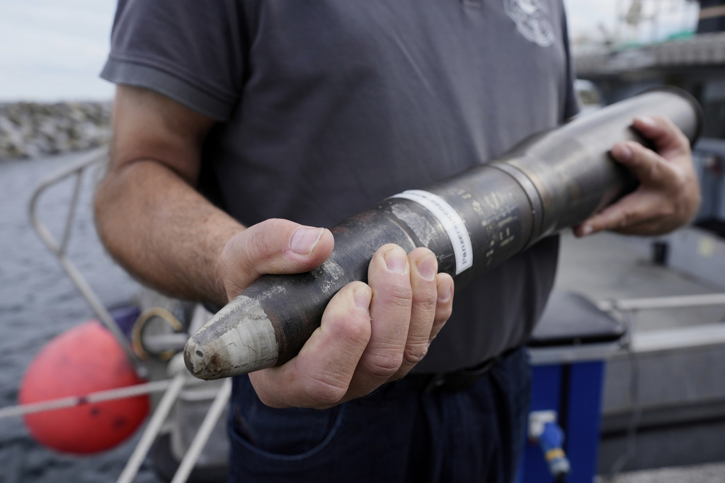 A representative of an ammunition recovery service shows a 78 millimetre artillery grenade as an example during a press tour to show the recovering of ammunition from World War II in the Baltic Sea, in Boltenhagen, Germany, Monday, Sept. 1, 2025. (AP Photo/Markus Schreiber)