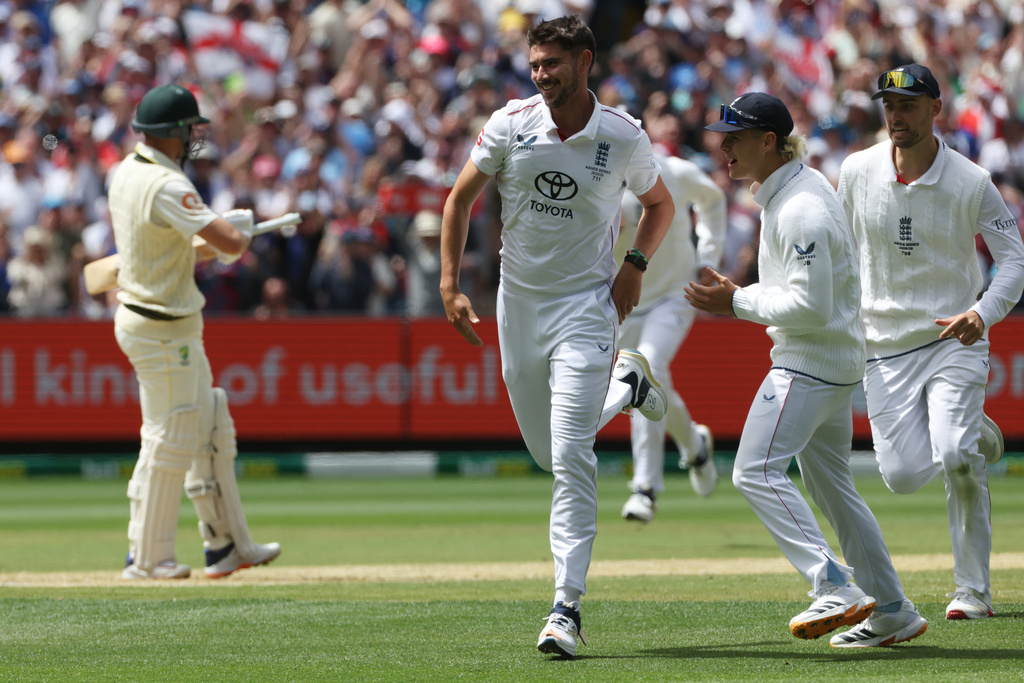 England's Josh Tongue, center, celebrates the wicket of Australia's Marnus Labuschagne, left, during their Ashes cricket test match in Melbourne, Friday, Dec. 26, 2025. (AP Photo/Hamish Blair)