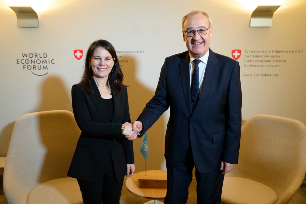 Swiss Federal President Guy Parmelin, right, shakes hands with United Nations' 80th General Assembly President and former German foreign minister Annalena Baerbock, left, prior to a bilateral meeting on the sideline of the 56th annual meeting of the World Economic Forum in Davos, Switzerland, Monday, Jan. 19, 2026. (Laurent Gillieron/Keystone via AP)