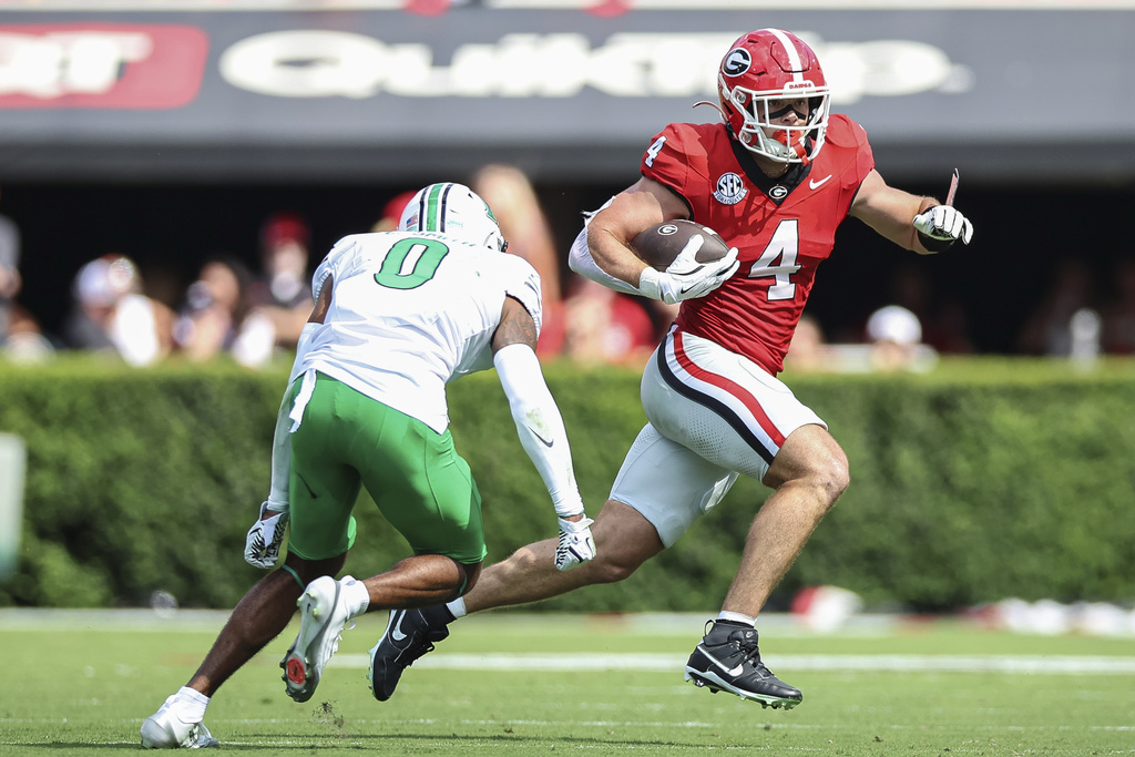 Georgia tight end Oscar Delp (4) runs with the football during the first half of an NCAA college football game against Marshall, Saturday, Aug. 30, 2025, in Athens, Ga. (AP Photo/Colin Hubbard)