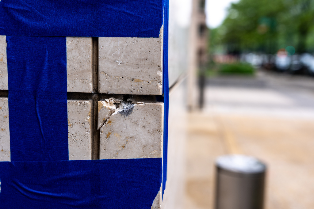 Blue tape is pictured around a possible bullet strike near the shooting scene near the scene of a shooting close to the White House, Sunday, May 24, 2026, in Washington. (AP Photo/Alex Brandon)