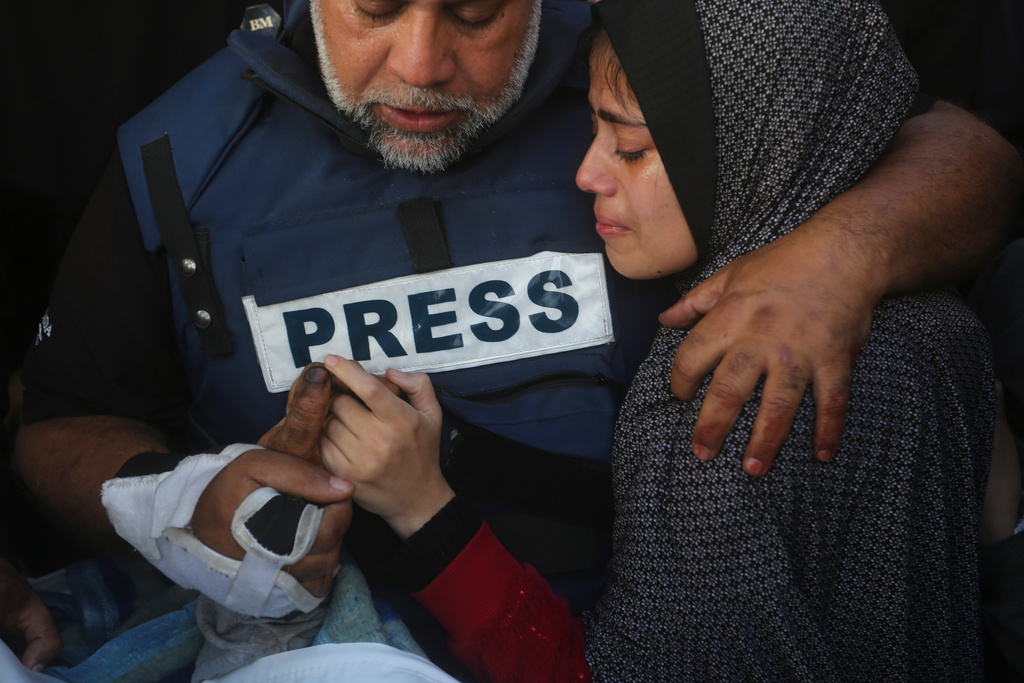 FILE - Al Jazeera journalist Wael Dahdouh holds the hand of his son, Hamza, who also worked for Al Jazeera and was killed in an Israeli airstrike, in Rafah, Gaza Strip, Jan. 7, 2024. (AP Photo/Hatem Ali, File)