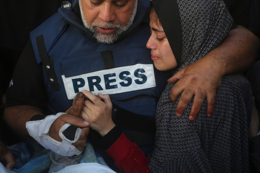 FILE - Al Jazeera journalist Wael Dahdouh holds the hand of his son, Hamza, who also worked for Al Jazeera and was killed in an Israeli airstrike, in Rafah, Gaza Strip, Jan. 7, 2024. (AP Photo/Hatem Ali, File) FILE - Al Jazeera journalist Wael Dahdouh holds the hand of his son, Hamza, who also worked for Al Jazeera and was killed in an Israeli airstrike, in Rafah, Gaza Strip, Jan. 7, 2024. (AP Photo/Hatem Ali, File)