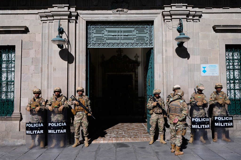 Military police stand outside the government palace while anti-government protests take place in La Paz, Bolivia, Monday, May 18, 2026. (AP Photo/Juan Karita)