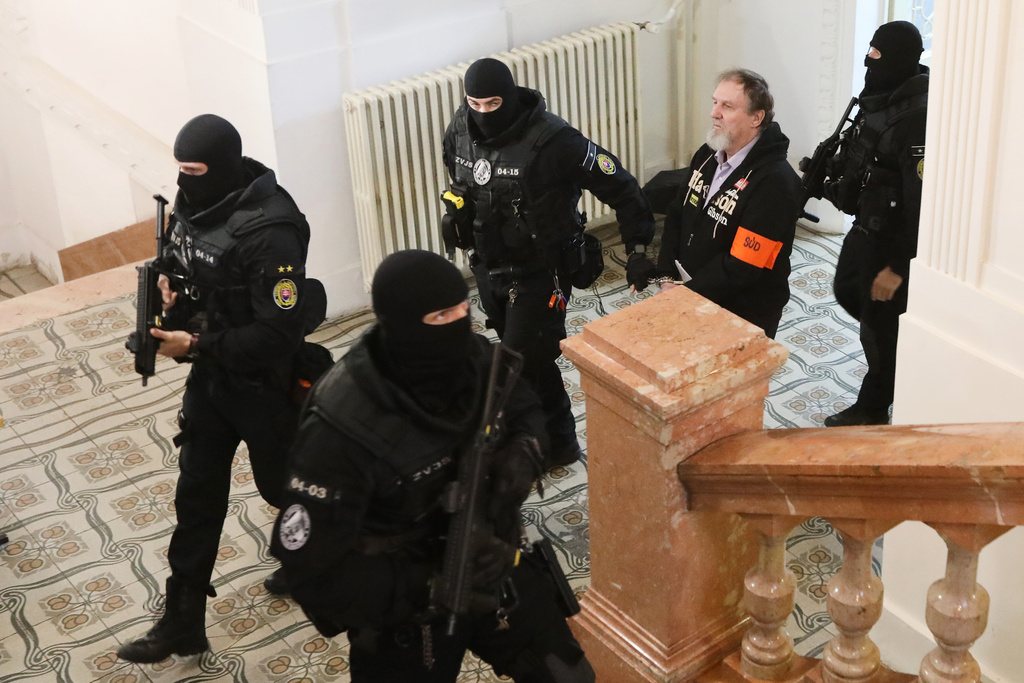 Juraj Cintula, who shot and seriously injured Prime minister of Slovakia Robert Fico last year, is convoyed at the Specialized Criminal Court in Banska Bystrica, Slovakia, Tuesday, Oct. 21, 2025. (Jan Kroslak/TASR via AP)