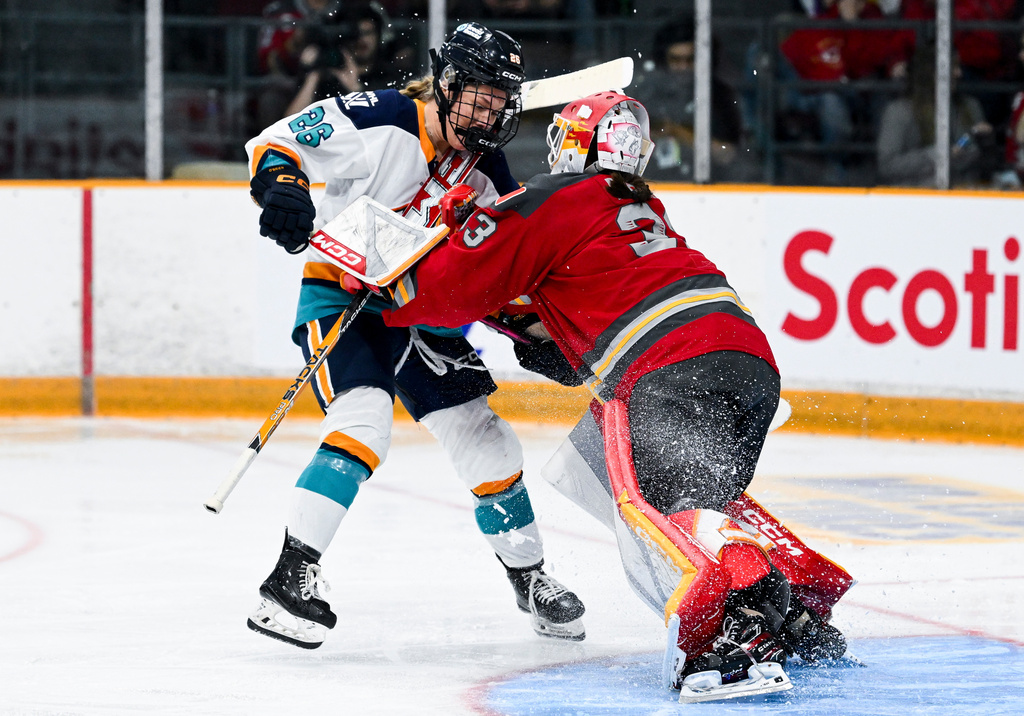 Ottawa Charge goaltender Gwyneth Philips, right, shoves New York Sirens' Casey O'Brien (26) following a stoppage in play during second-period PWHL hockey game action in Ottawa, Ontario, Saturday, April 18, 2026. (Spencer Colby/The Canadian Press via AP)