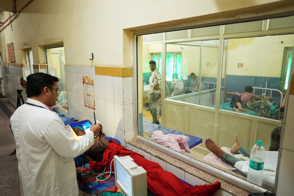 FILE - Dr. Abhishek Pranayami examines a patient suffering from a heat-related illness amid high temperatures at a district government hospital in Banda, northern Indian state of Uttar Pradesh, June 19, 2026 (AP Photo/Rajesh Kumar Singh, File)