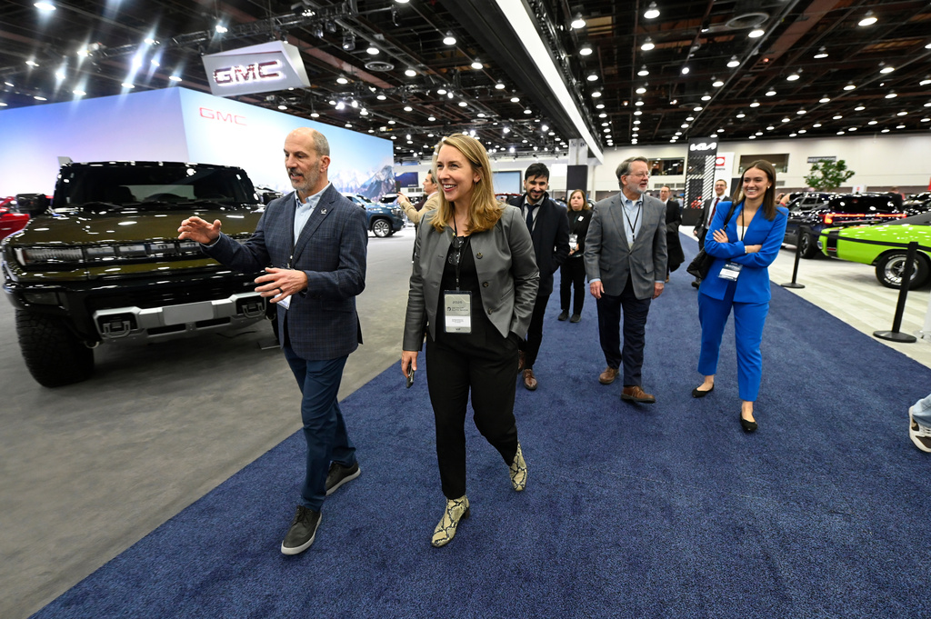 FILE - Todd Szott, left, president of the Detroit Auto Dealers Association and dealer partner at Szott Auto Group, talks with Rep. Hillary Scholten, D-Mich., center left, as Sen. Gary Peters, D-Mich., second from right, talks with his press secretary, Brennan Sullivan, as they tour the Detroit Auto Show, Friday, Jan. 10, 2025, in Detroit. (AP Photo/Jose Juarez. file)