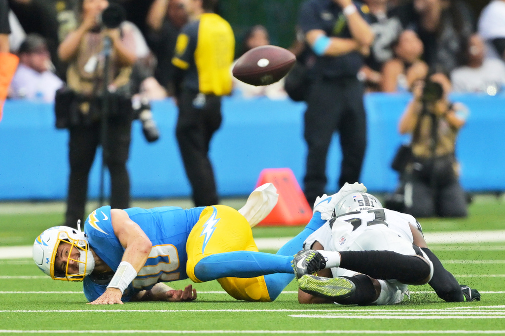 Los Angeles Chargers quarterback Justin Herbert (10) fumbles as he is tackled by Las Vegas Raiders defensive end Malcolm Koonce (51) during the second half of an NFL football game in Inglewood, Calif., Sunday, Sept. 20, 2026. (AP Photo/Jayne Kamin-Oncea)