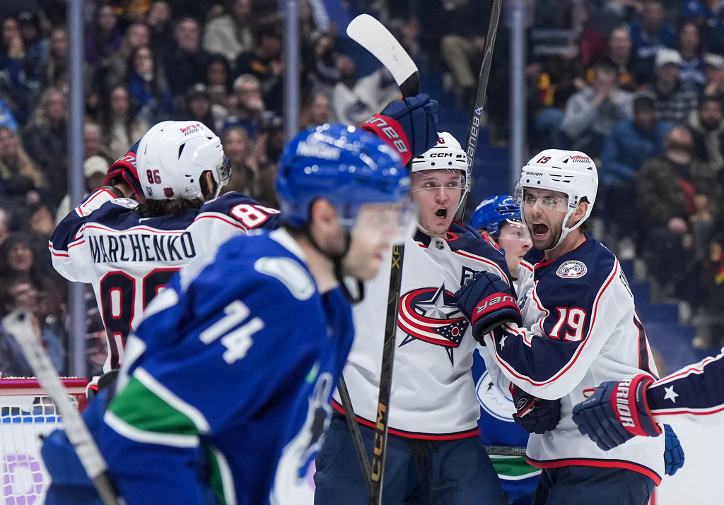 Columbus Blue Jackets' Dmitri Voronkov, back centre, Adam Fantilli, back right, and Kirill Marchenko celebrate Voronkov's goal as Vancouver Canucks' Jake DeBrusk skates past during the second period of an NHL hockey game, in Vancouver, on Saturday, Nov. 8, 2025. (Darryl Dyck/The Canadian Press via AP)