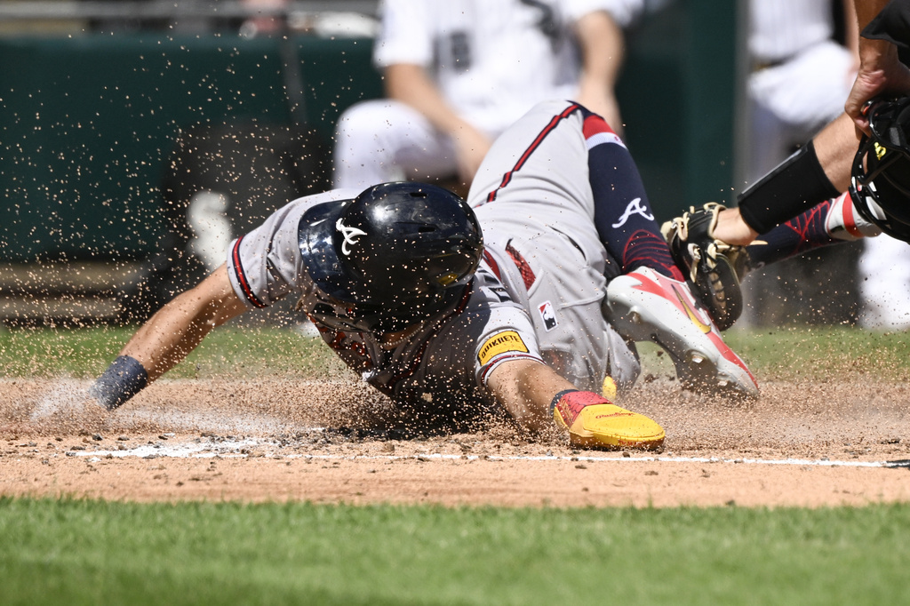 Atlanta Braves' Mauricio Dubón scores past the Chicago White Sox catcher Drew Romo during the third inning of a baseball game, Thursday, Aug. 20, 2026, in Chicago. (AP Photo/Matt Marton)