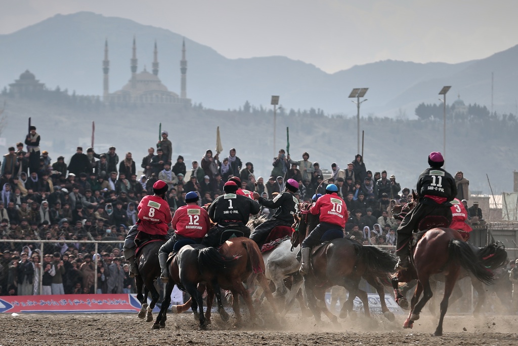 Riders from the Sar-e-Pul and Badakhshan teams compete in the final of Afghanistan's annual buzkashi tournament, a traditional equestrian sport in which riders score points using a fake goat carcass, on the outskirts of Kabul, Afghanistan, Monday, Dec. 22, 2025. (AP Photo)