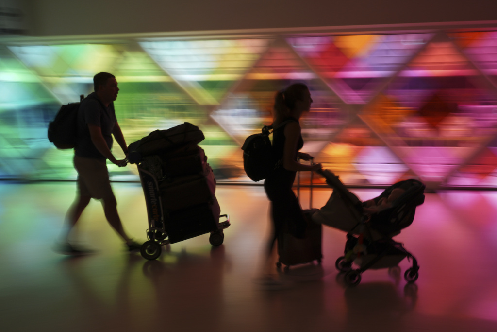 Travelers arrive at Miami International Airport at the start of the Labor Day weekend, Friday, Aug. 29, 2025, in Miami. (AP Photo/Rebecca Blackwell)