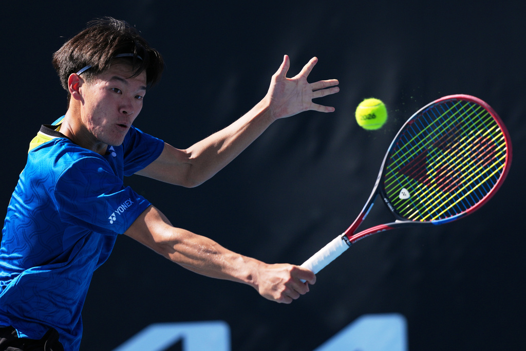 Michael Zheng of the U.S. plays a backhand return to Corentin Moutet of France during their second round match at the Australian Open tennis championship in Melbourne, Australia, Wednesday, Jan. 21, 2026. (AP Photo/Dar Yasin)