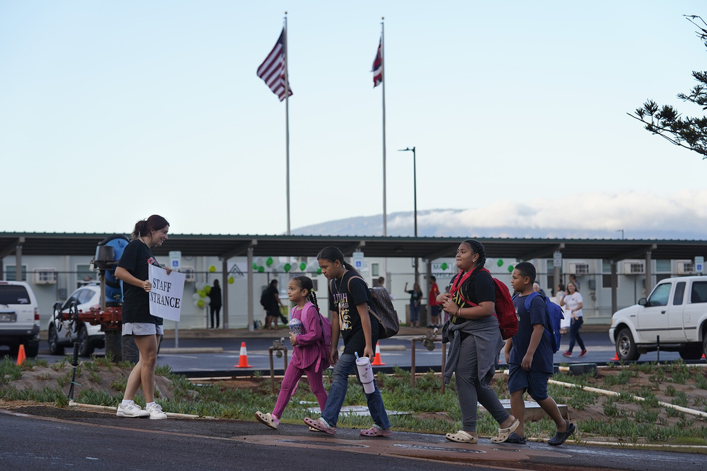 Students walk to the temporary Pulelehua campus of King Kamehameha III Elementary School in Lahaina, Hawaii, on Monday, April 1, 2024. The original school was destroyed in the August 2023, fires. (Kevin Fujii/Honolulu Civil Beat via AP)