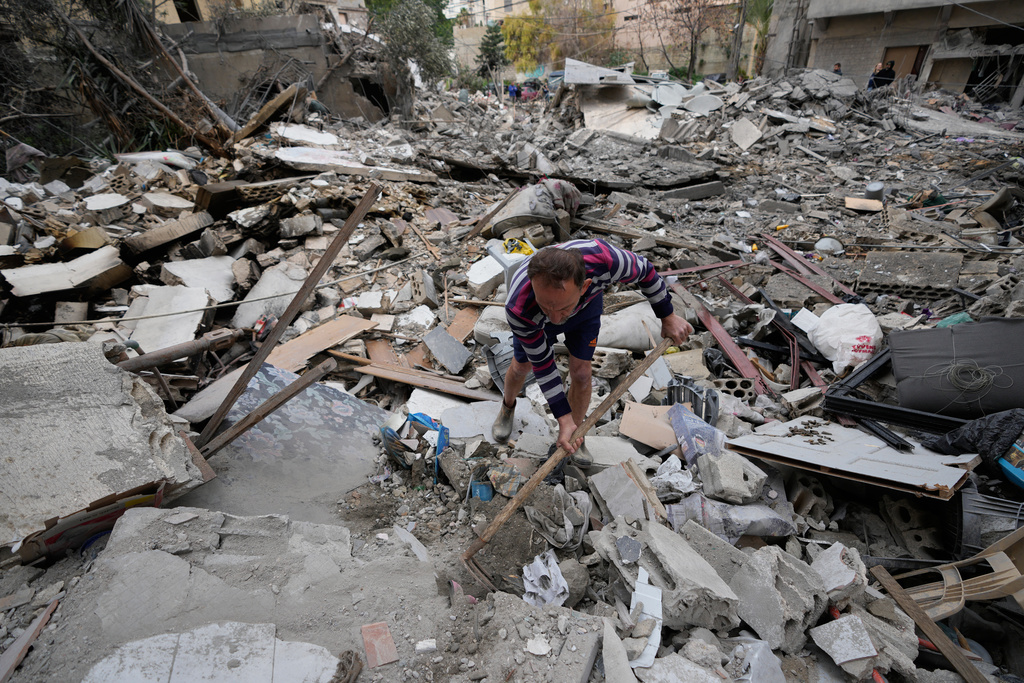 A man removes rubbles as he looks for missed stuff from his destroyed house that was hit in an Israeli airstrike in the southern port city of Tyre, Lebanon, Thursday, March 26, 2026. (AP Photo/Hussein Malla)