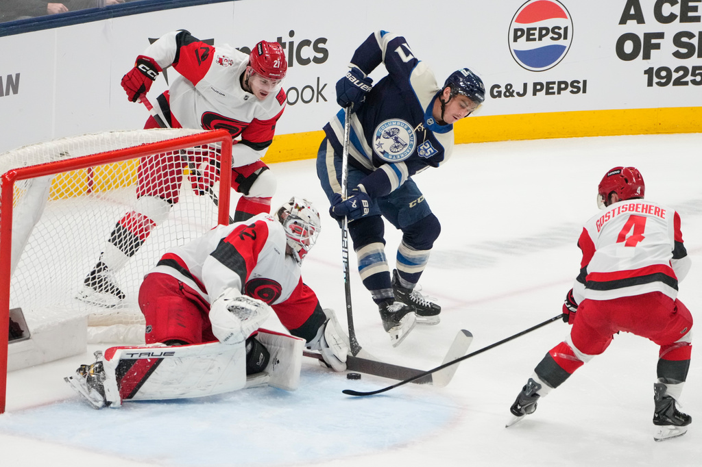 Carolina Hurricanes goaltender Brandon Bussi (32) blocks a shot by Columbus Blue Jackets left wing Mason Marchment (17) in the second period of an NHL game in Columbus, Tuesday, March 31, 2026. (AP Photo/Sue Ogrocki)