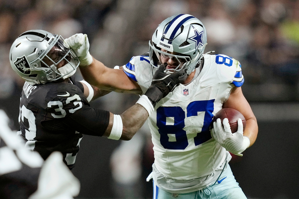 Dallas Cowboys tight end Jake Ferguson (87) tries to push Las Vegas Raiders linebacker Jamal Adams (33) aside during the second half of an NFL football game Monday, Nov. 17, 2025, in Las Vegas. (AP Photo/John Locher)