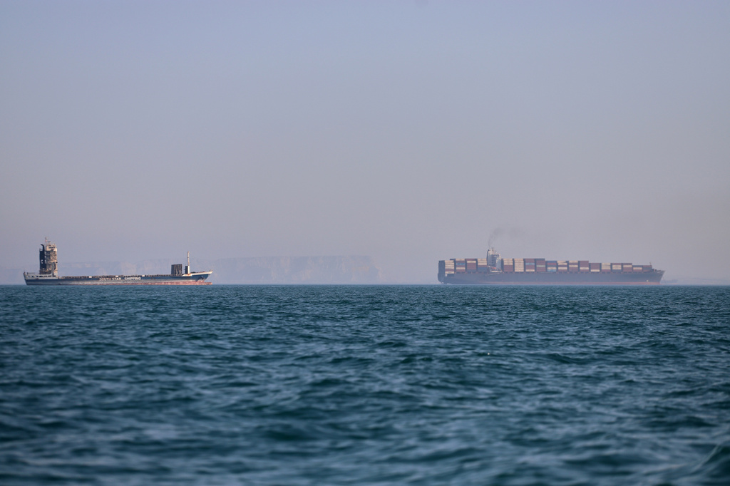 A container ship, right, and a cargo vessel are seen in the Strait of Hormuz off Bandar Abbas, Iran, Wednesday, June 17, 2026. (Amirhosein Khorgooi/ISNA via AP)