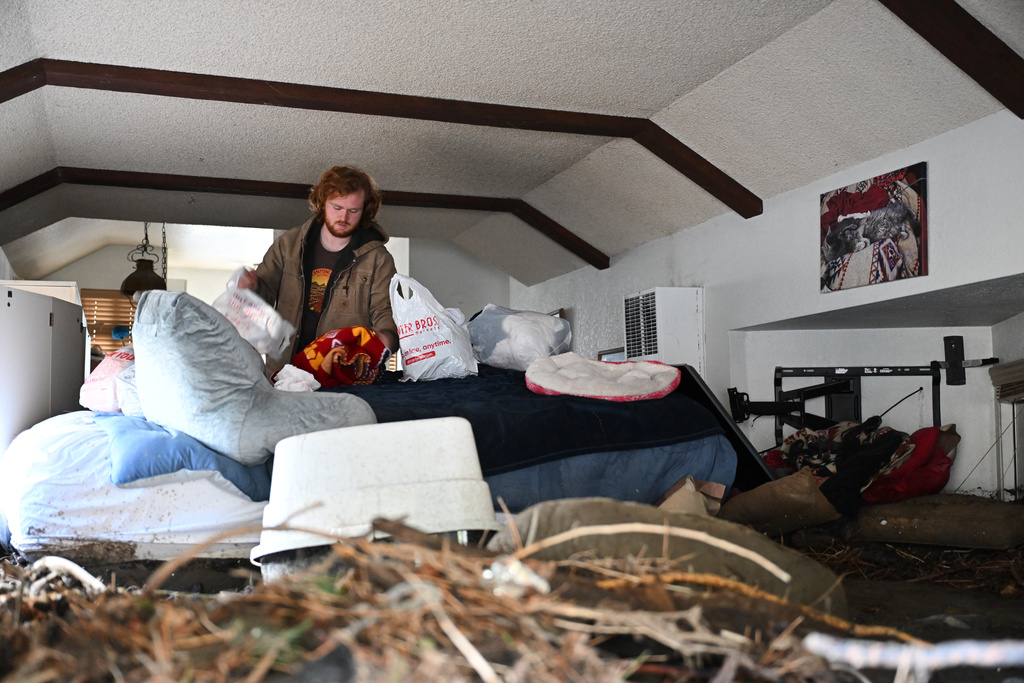Davey Schneider recovers items from his storm-damaged home on Thursday, Dec. 25, 2025, in Wrightwood, Calif. (AP Photo/William Liang)
