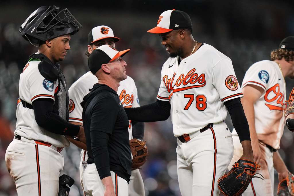 Baltimore Orioles pitcher Yennier Cano (78) smiles with manager Craig Albernaz during a pitching substitution in the ninth inning of a baseball game against the Arizona Diamondbacks, Tuesday, April 14, 2026, in Baltimore. (AP Photo/Stephanie Scarbrough)
