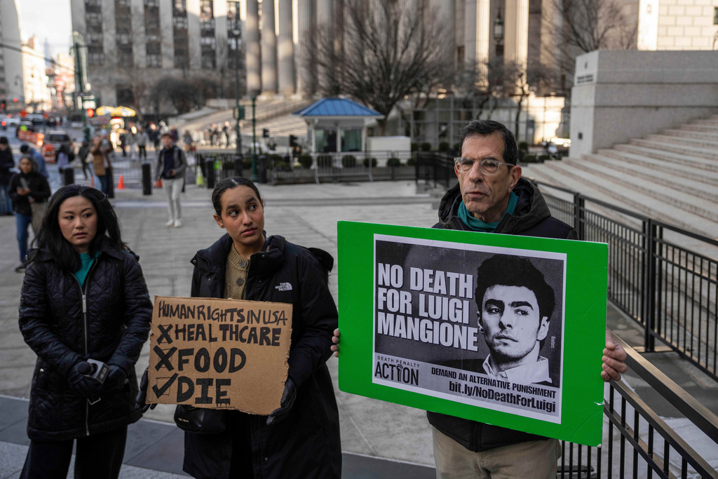 Supporters of Luigi Mangione raise signs outside Manhattan federal court, Friday, Jan. 9, 2026, in New York. (AP Photo/Yuki Iwamura)